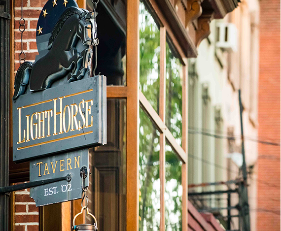 Close up of wooden sign for White Horse Tavern in Jersey City, says established ‘02